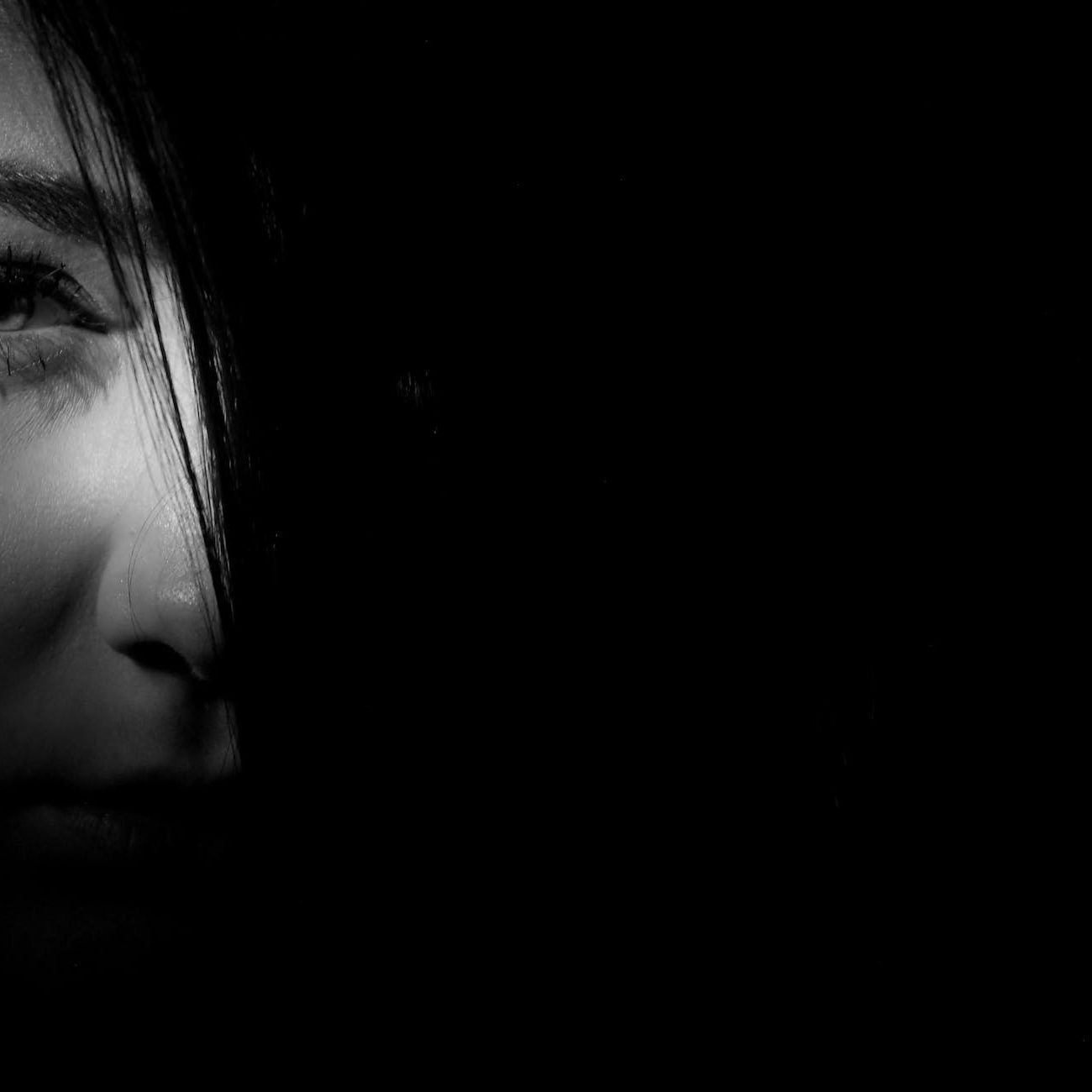 half a portrait face stares from the dark