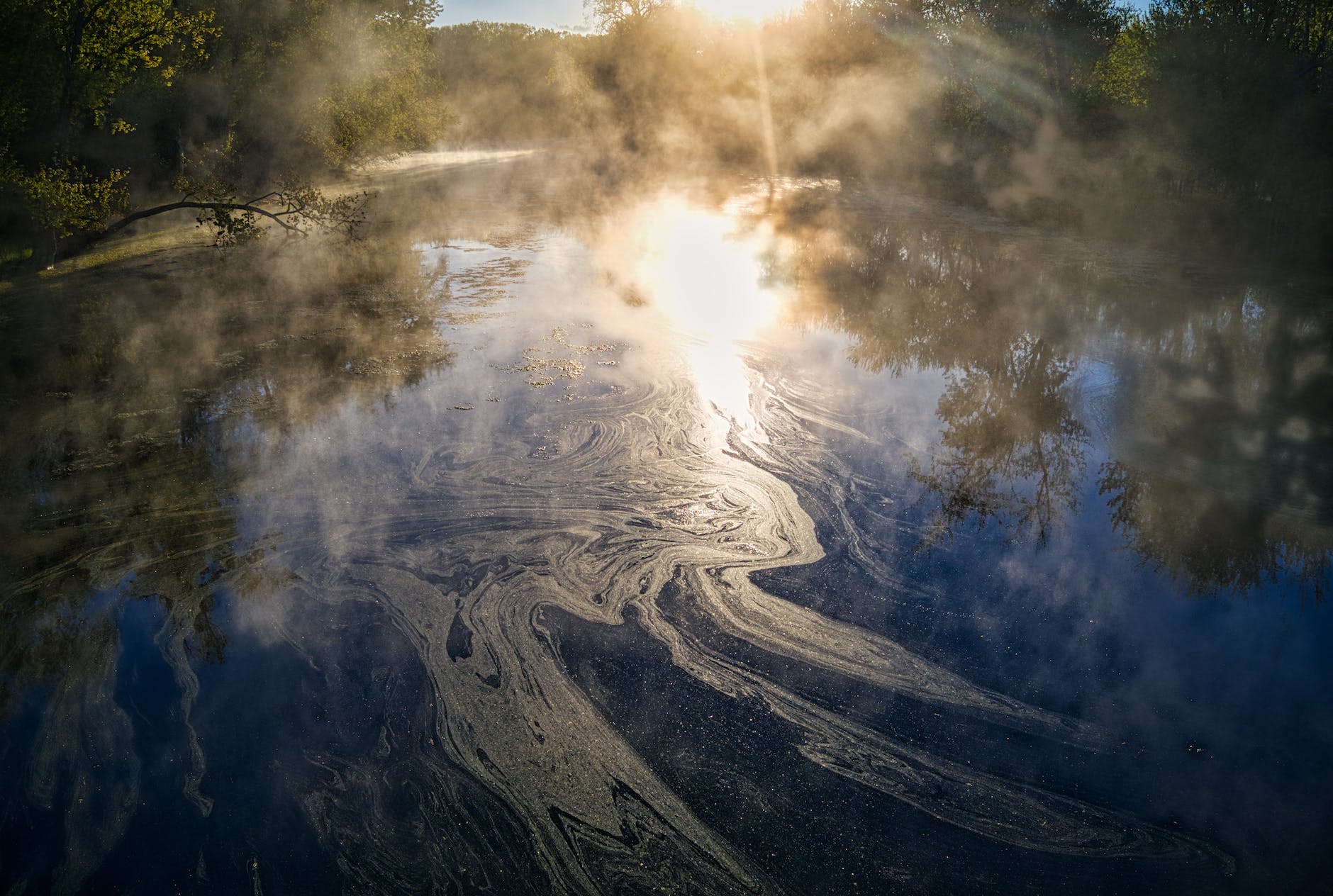 oily sheen on water sunlight reflects off an oily sheen on a river