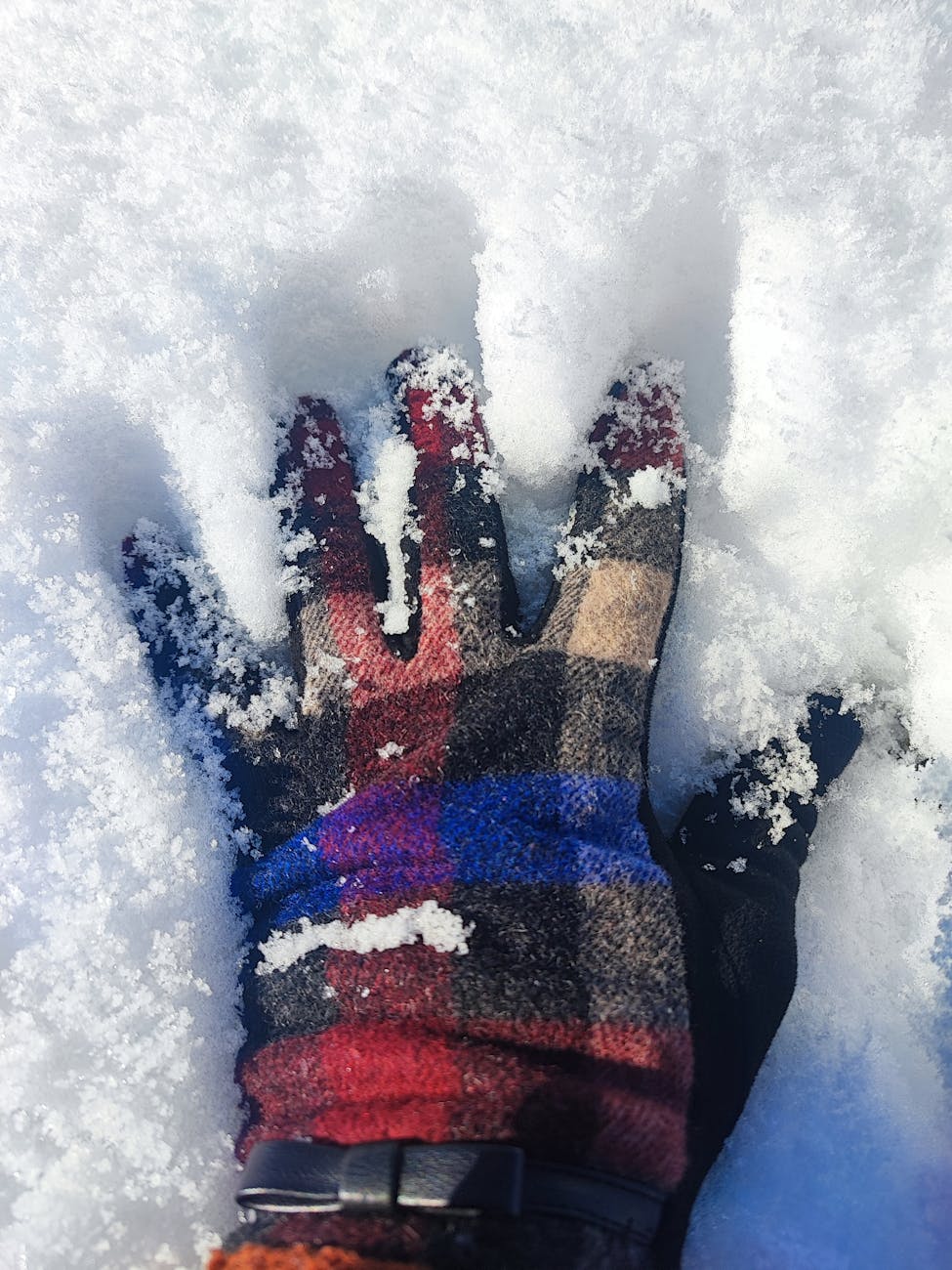 winter glove pressing into the snow
